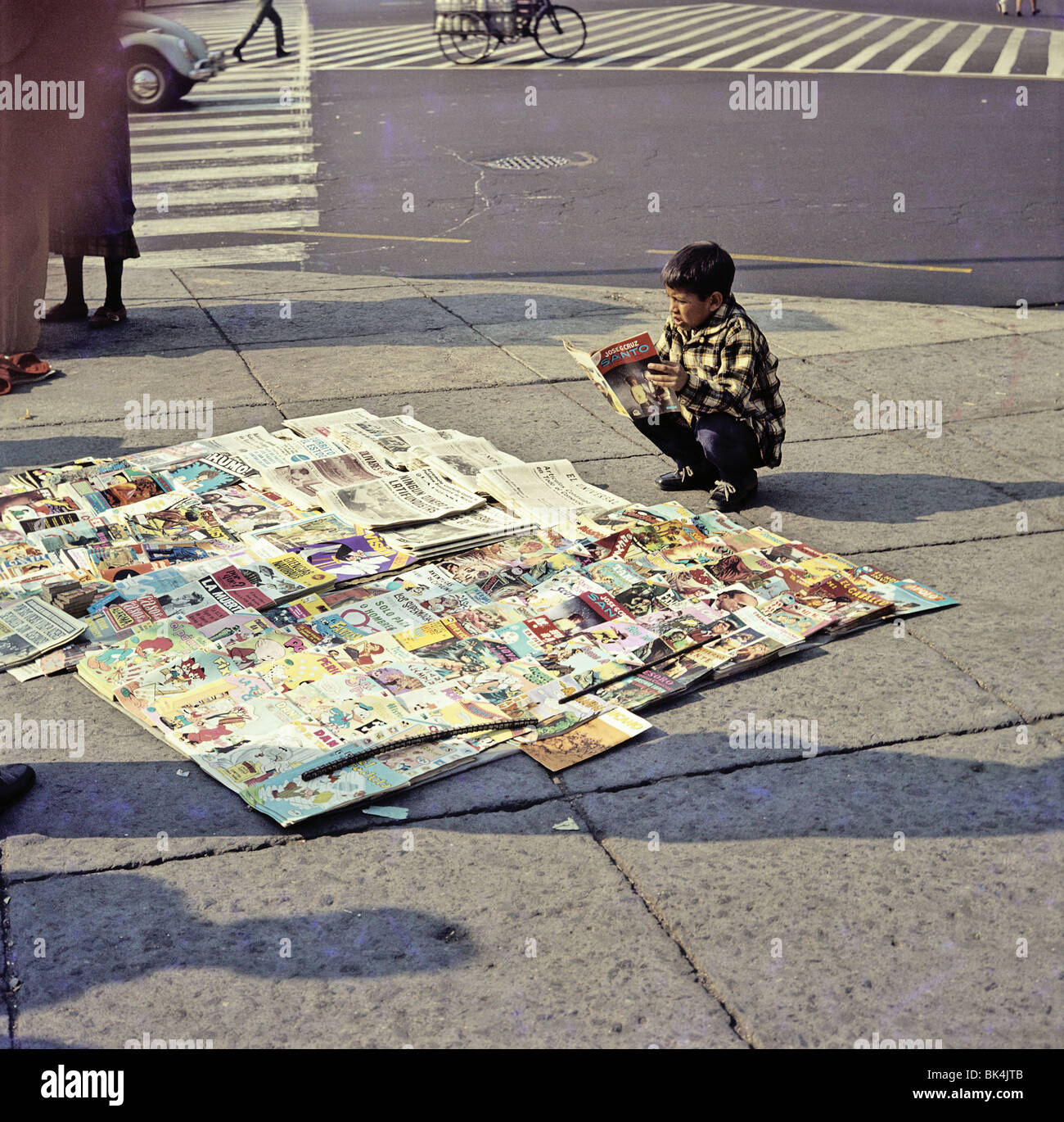 Un ragazzo vendita di quotidiani e riviste su un angolo di strada, Messico Foto Stock