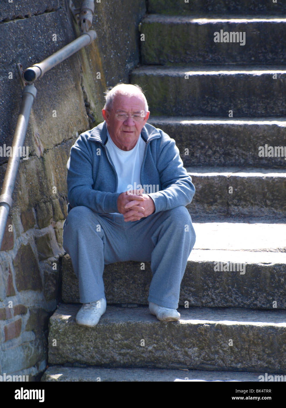 Il vecchio uomo seduto sui gradini Foto Stock