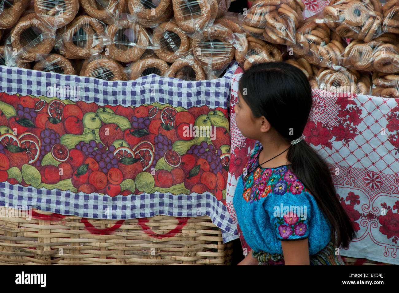 Ragazza a piedi nella parte anteriore del mercato Panajachel Guatemala Foto Stock