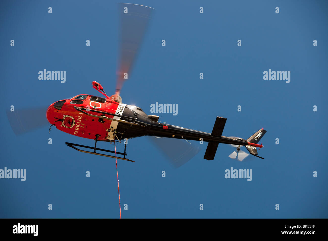 Parco nazionale di personale usando un elicottero per spostare merci nelle montagne innevate, Australia. Foto Stock
