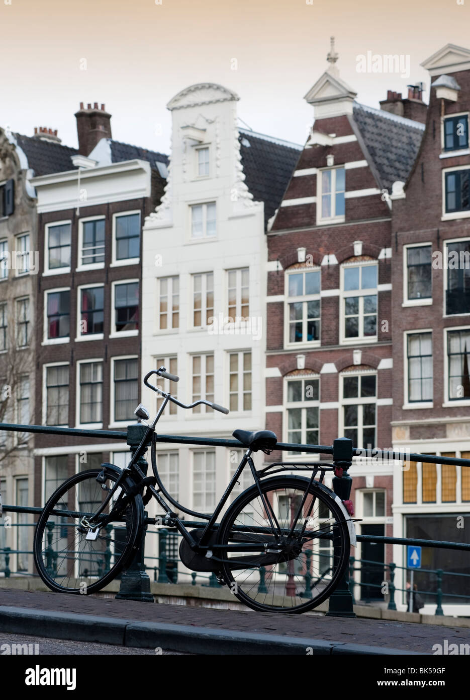 Bicicletta parcheggiata sul ponte sopra il canale nel centro di Amsterdam Paesi Bassi Foto Stock