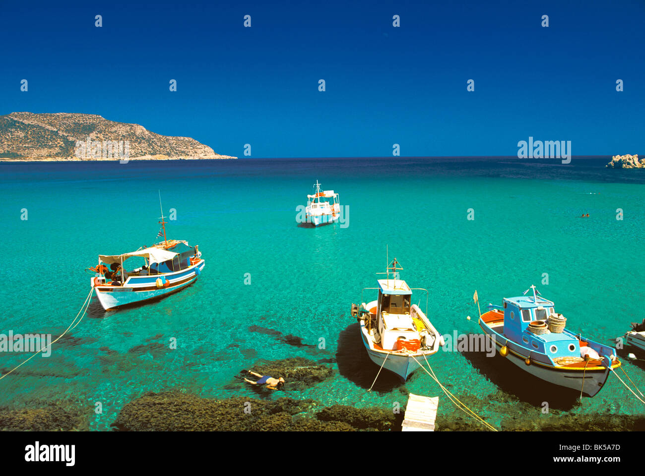 Fishiing barche e l uomo lo snorkeling a Anopi Beach, Karpathos, Dodecaneso, isole greche, Grecia, Europa Foto Stock