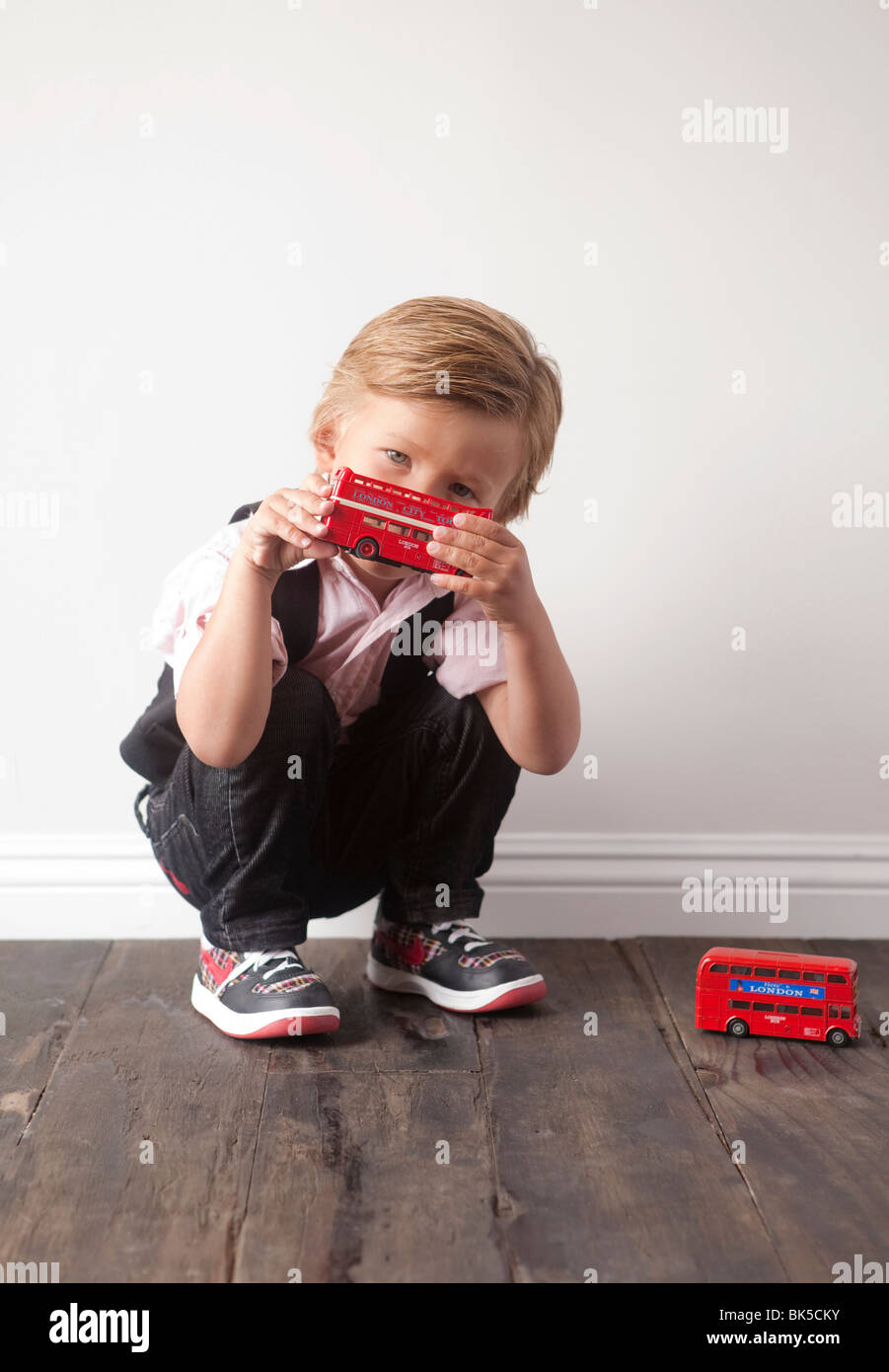 Giovane ragazzo giocando con automobili giocattolo Foto Stock