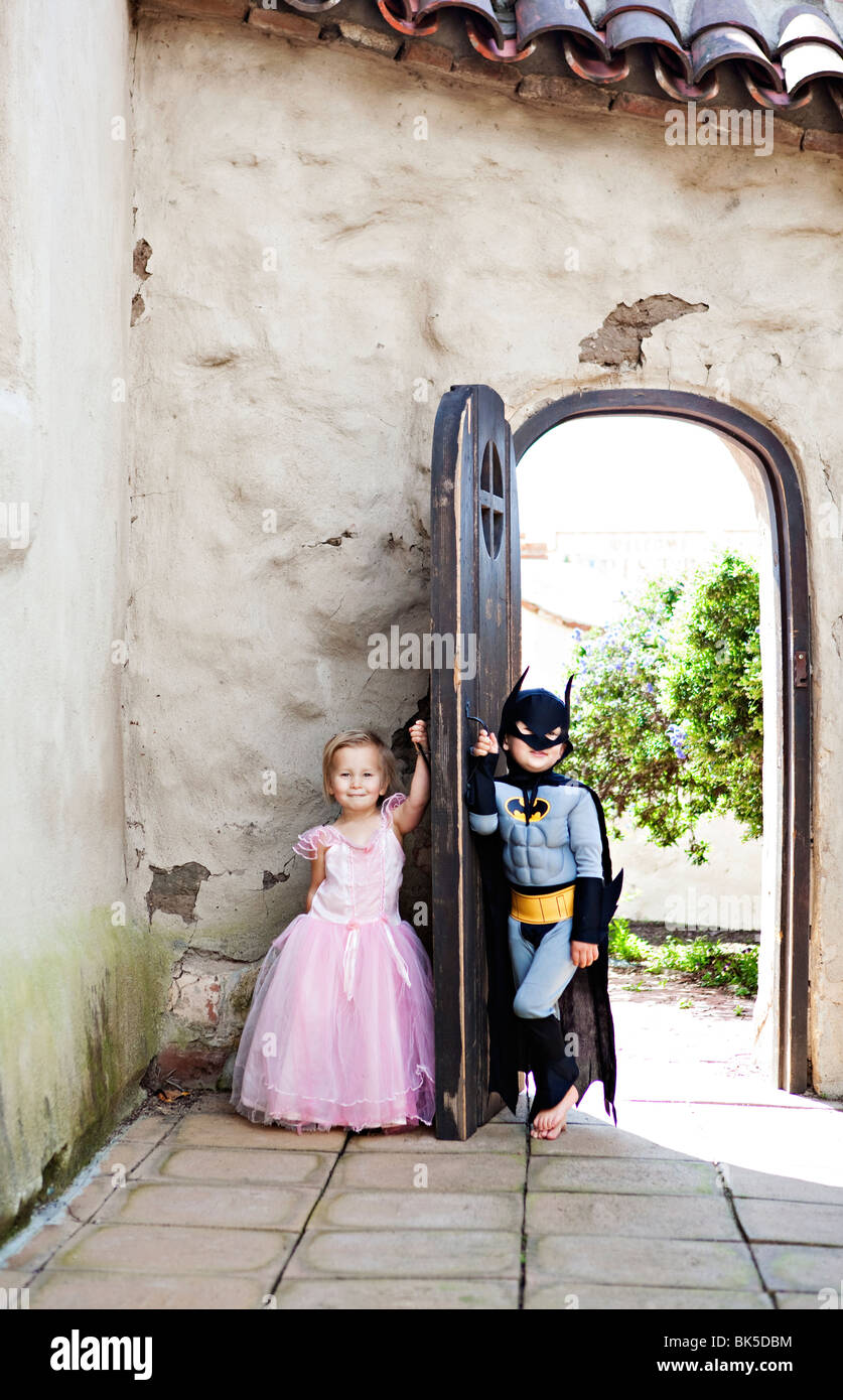 Ragazza in costume di Principessa e il ragazzo in costume di batman giocando Foto Stock