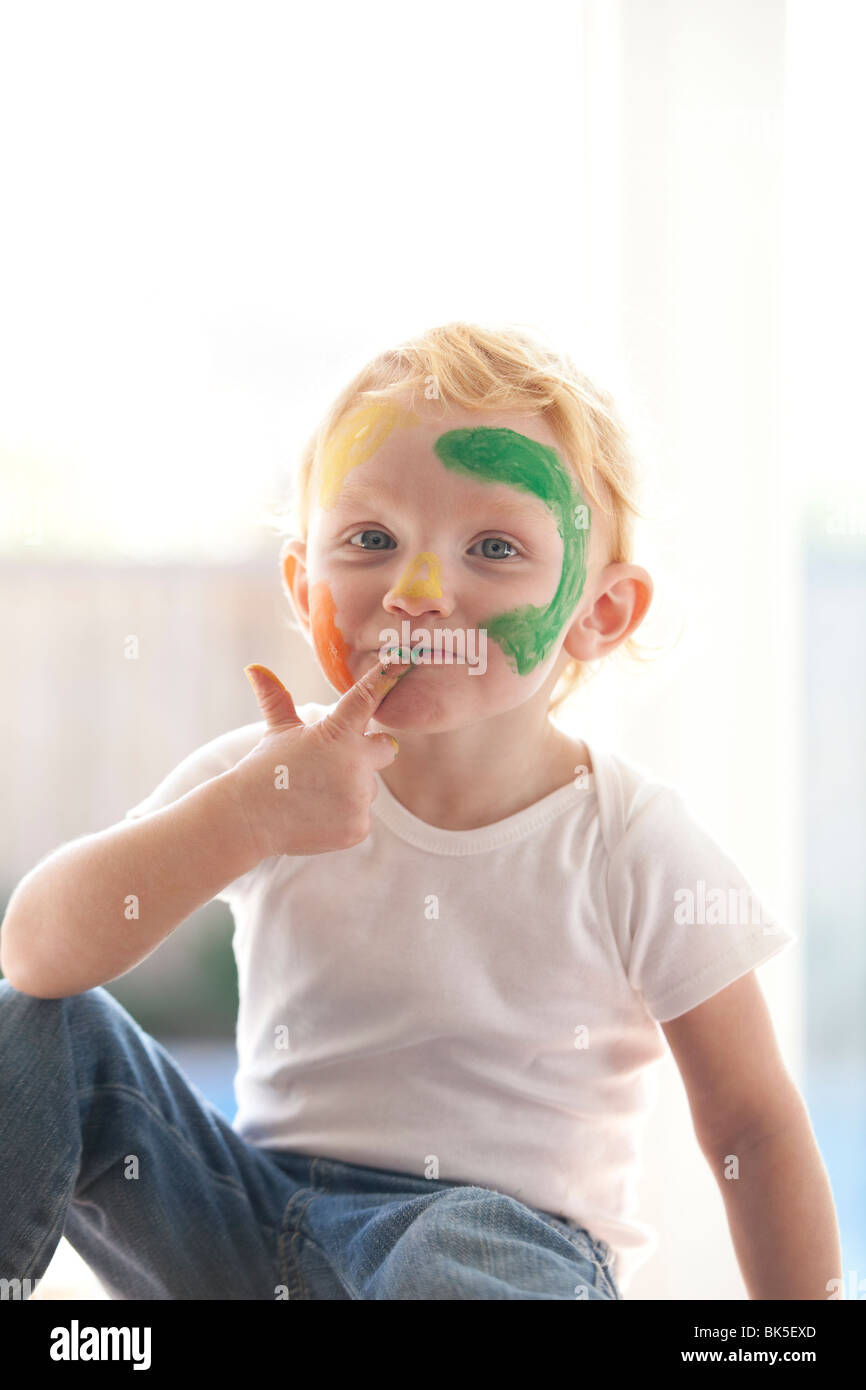 Bambina giocando con il dito di vernice Foto Stock