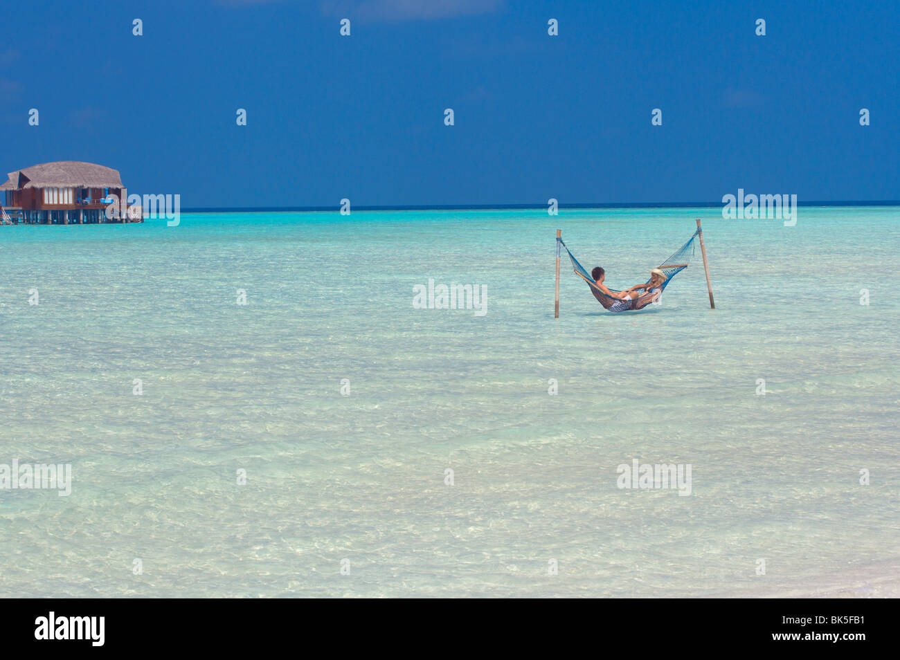 Giovane rilassante in amaca, Maldive, Oceano Indiano, Asia Foto Stock