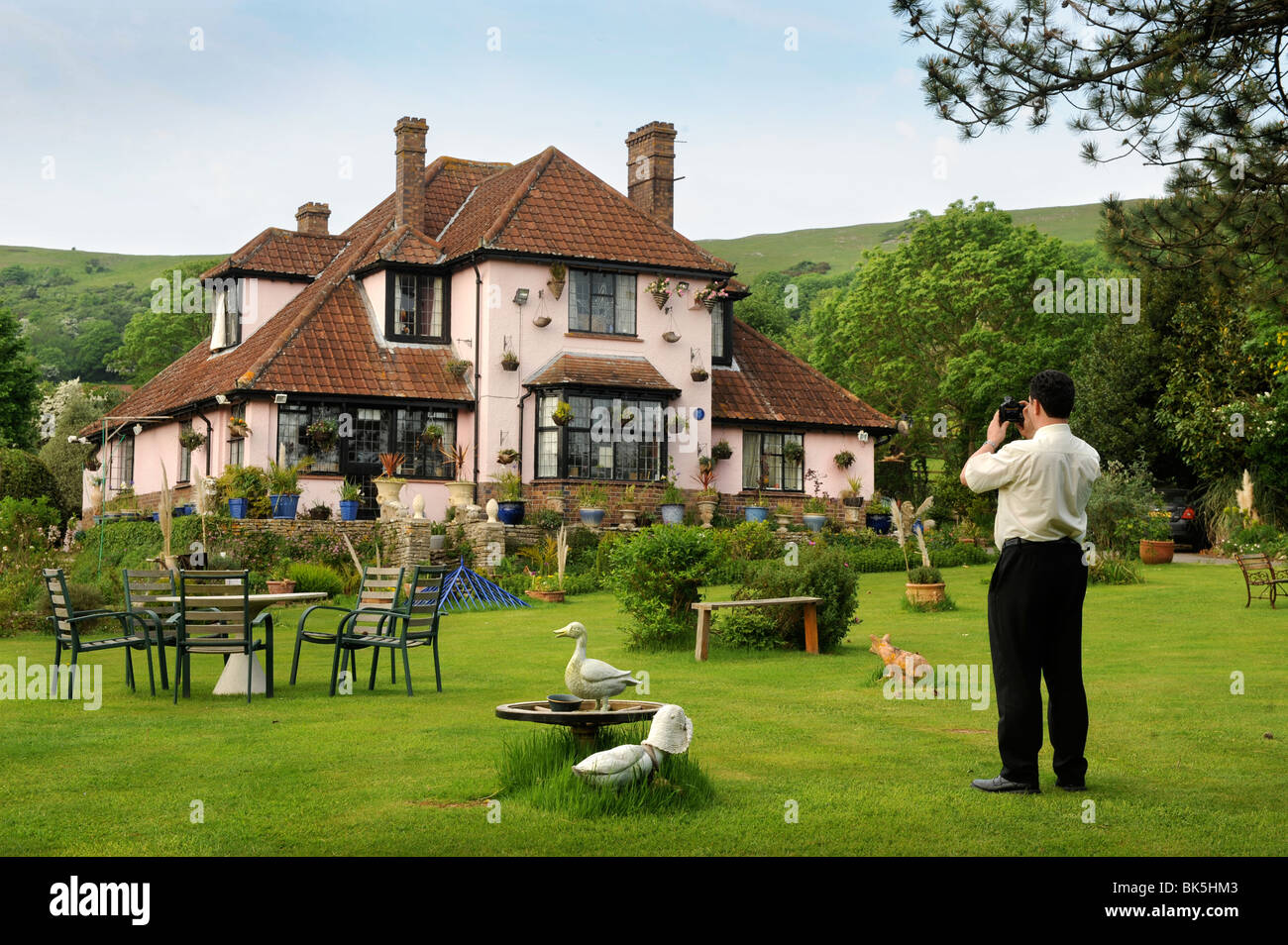 Un agente immobiliare prende una fotografia di titubanze verso il basso casa del villaggio di croce, Somerset - ex casa del tardo Frankie Ho Foto Stock