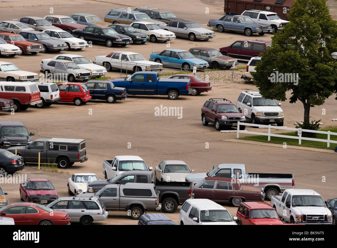 Parcheggio al di fuori di una fabbrica di noi. Per la maggior parte le auto più vecchie e non molto ben mantenuto. Il Nebraska, American Mid West. Foto Stock