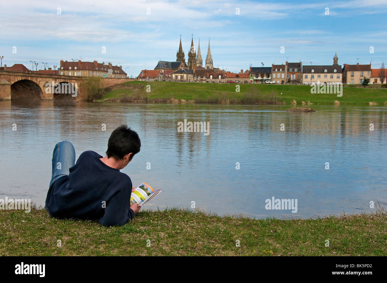 Donna disteso sulle rive di Allier di fronte alla città di Moulins. Auvergne. La Francia. Foto Stock