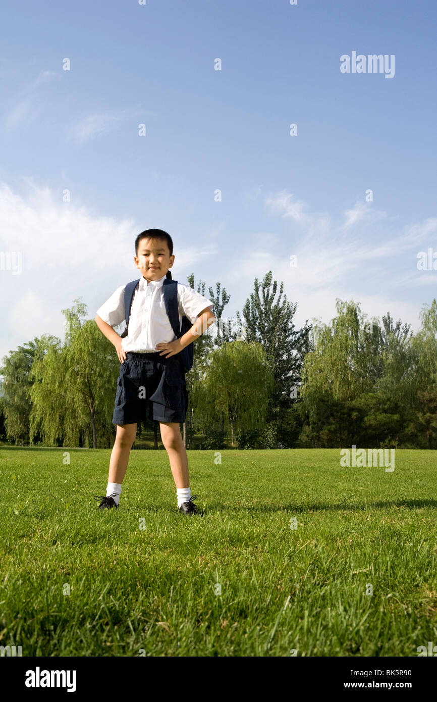 Scuola elementare studente nel parco Foto Stock