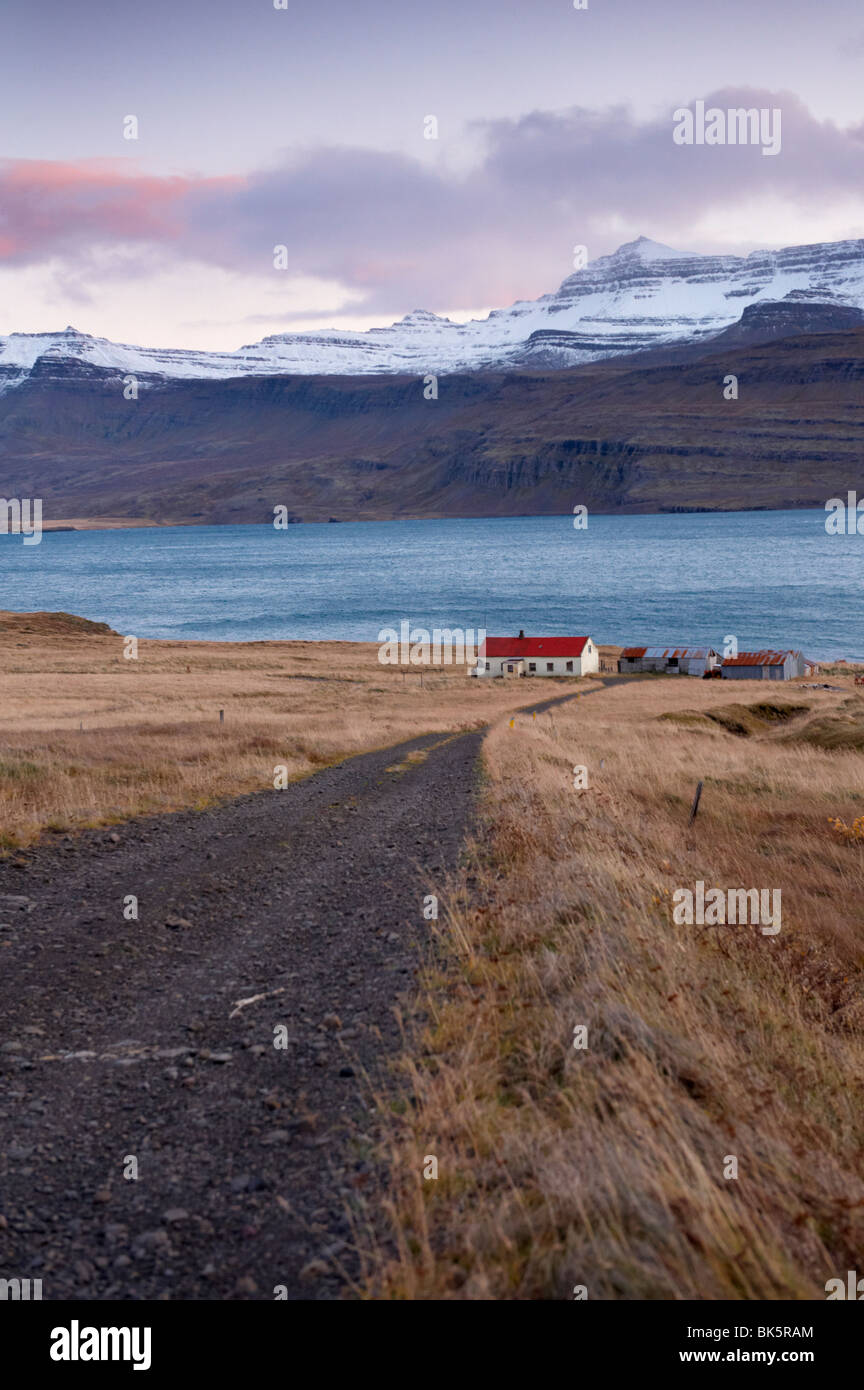 Dal tetto rosso house e montagne innevate nel fiordo di Reydarfjordur, Est fiordi, Islanda, regioni polari Foto Stock