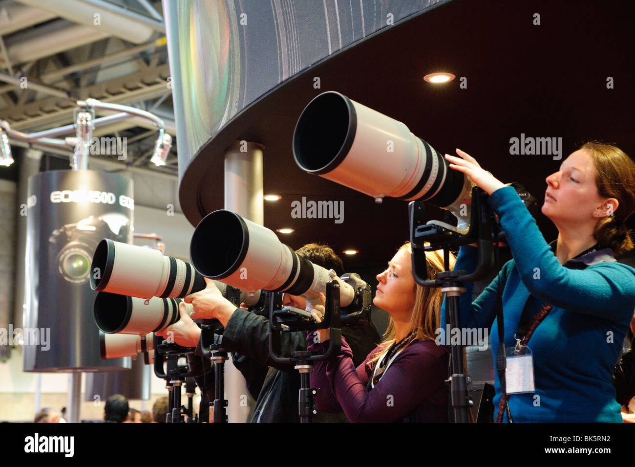 Gli appassionati di fotografia di esaminare una serie di ottiche Canon a una fiera commerciale al NEC di Birmingham, Inghilterra Foto Stock