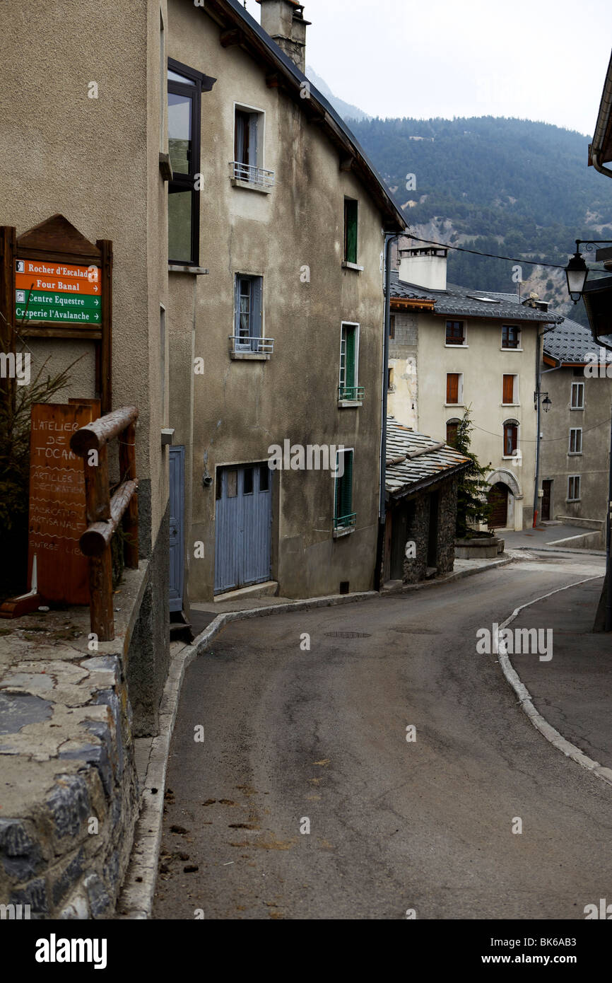 Street view in Francese di Sci Alpino villaggio di Aussois, che mostra la curva verso il basso della strada nonché firmare messaggi Foto Stock