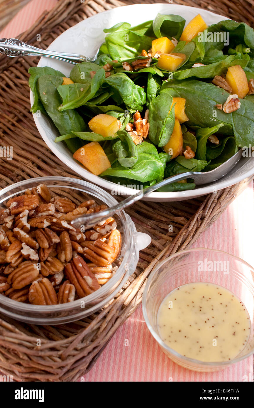 Sana insalata vegetariana con mature le pesche, le noci pecan e condimento. Foto Stock