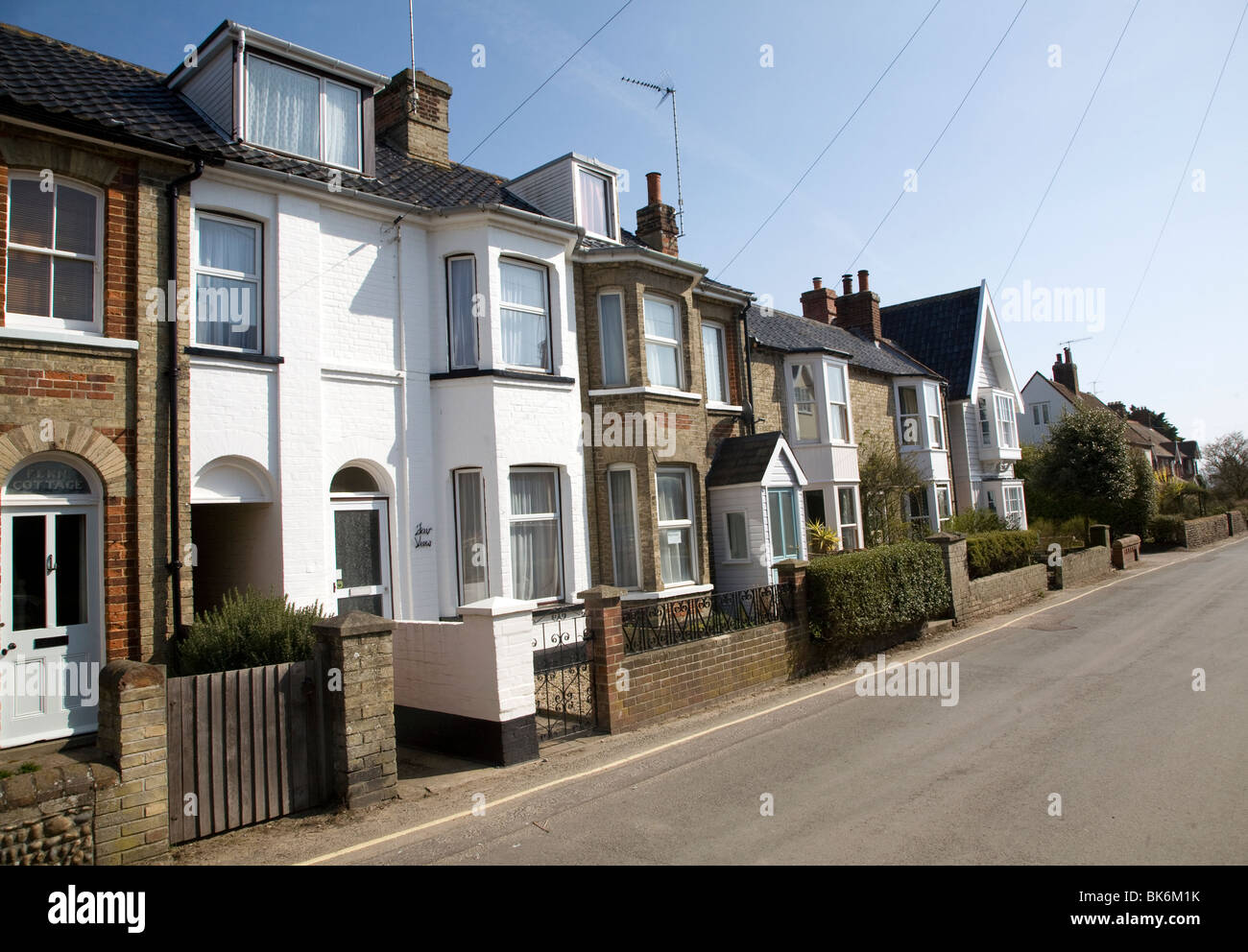 Fila di case con linee telefoniche Walberswick, Suffolk Foto Stock