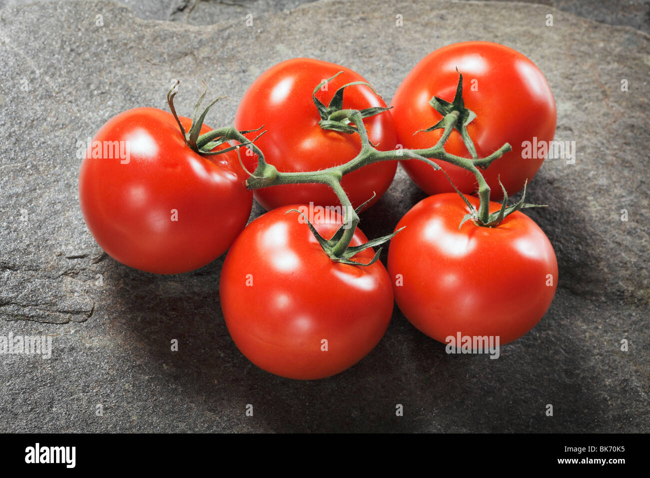 Pomodori freschi maturi su sfondo di pietra Foto Stock