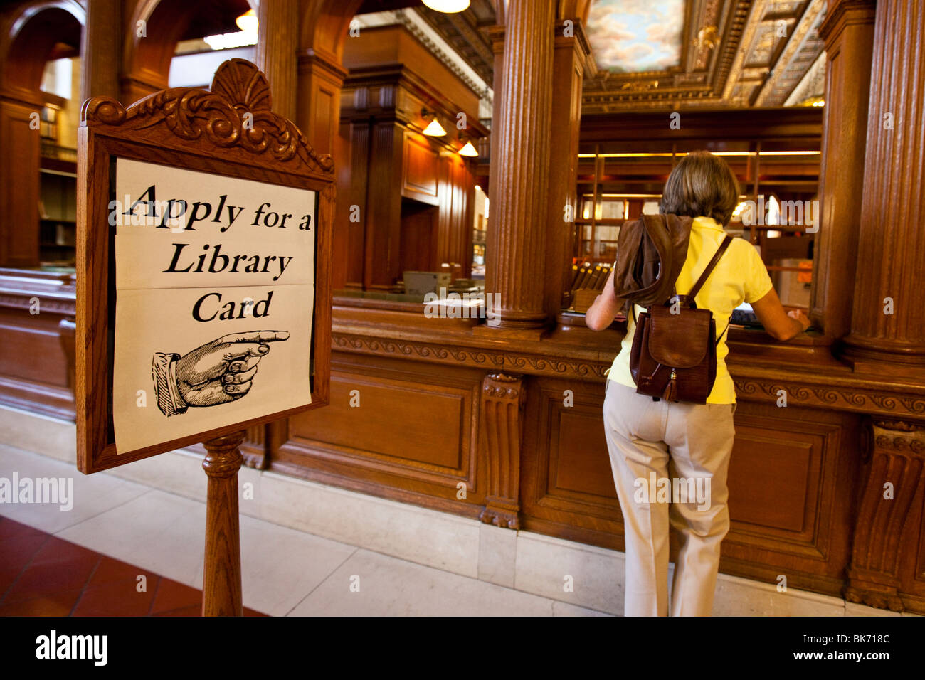 Donna di applicare per una Library card presso il ramo principale della Biblioteca Pubblica di New York, Manhattan NYC Foto Stock