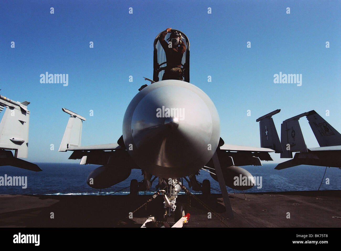 Un pilota navale pulisce e servizi una F-18A Hornet a bordo della portaerei USS Nimitz nel Golfo Persico, durante il 2003 Guerra in Iraq. Foto Stock