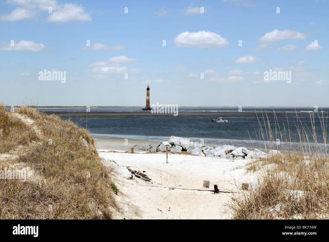 Follia Island Beach con il faro in distanza, Charleston, Sc, STATI UNITI D'AMERICA. La stoltezza isola è appena a sud del centro storico di Charleston, Sc Foto Stock