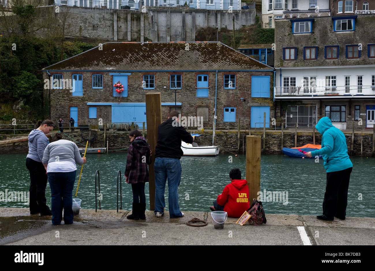 I vacanzieri la pesca dei granchi sulla banchina a Looe in Cornovaglia. Foto di Gordon Scammell Foto Stock