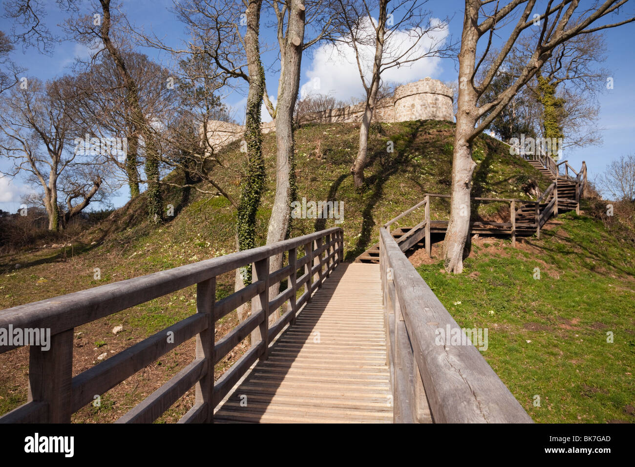 Llangoed, Isola di Anglesey (Ynys Mon), il Galles del Nord, Regno Unito. Passerella in legno attraverso il fossato intorno a Castell Aberlleiniog rovine del castello Foto Stock