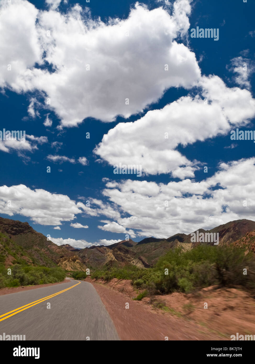 La guida su una strada attraverso un paesaggio di montagna. Foto Stock