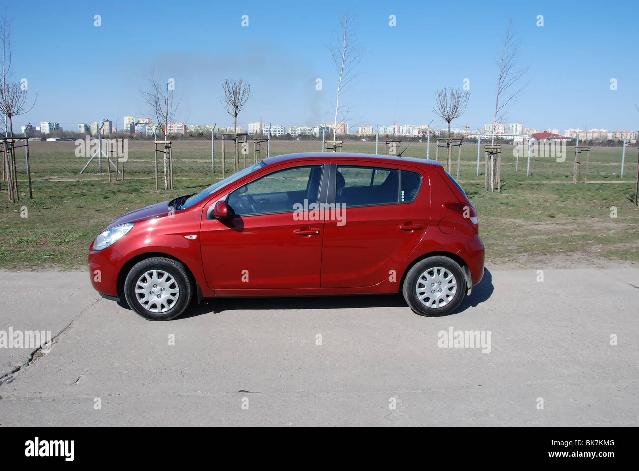 Hyundai i20 1.2 - Il mio 2008 - Rosso metalizzato - cinque porte (5D) - Coreano ultracompatto che sta popolare city car - su uno spazio di parcheggio Foto Stock