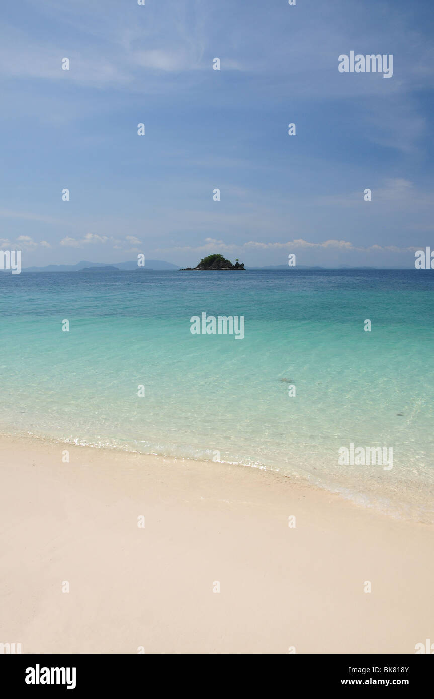 Spiaggia sabbiosa tropicale che si affaccia su un isola deserta Foto Stock