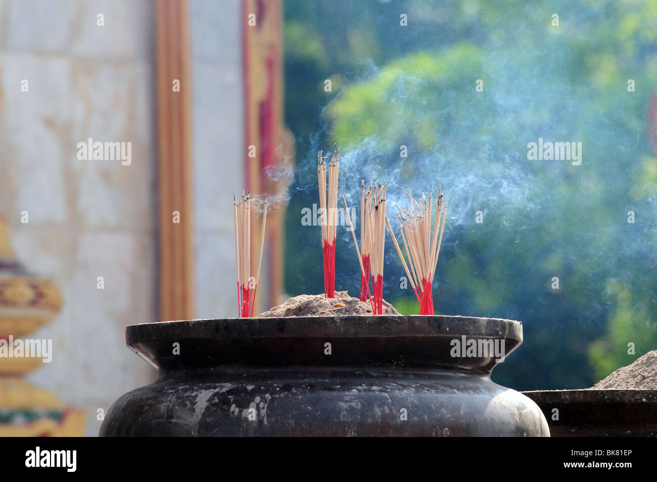 Bastoncini di incenso bruciare al di fuori del tempio buddista in Thailandia Foto Stock