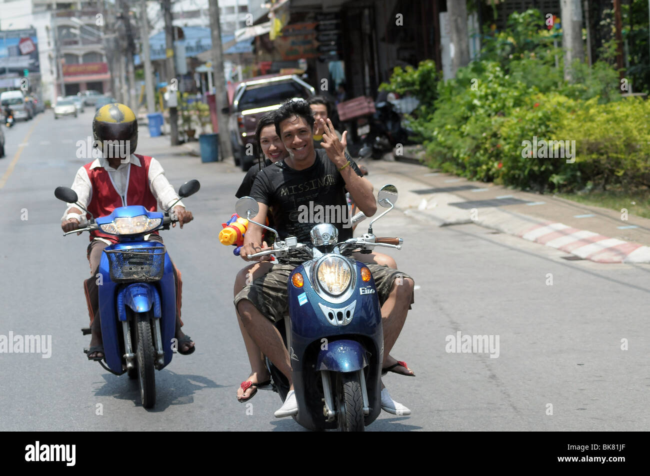 Persona su scooter in Thailandia facendo un gesto locale di Defiance, da Tony Rusecki Foto Stock