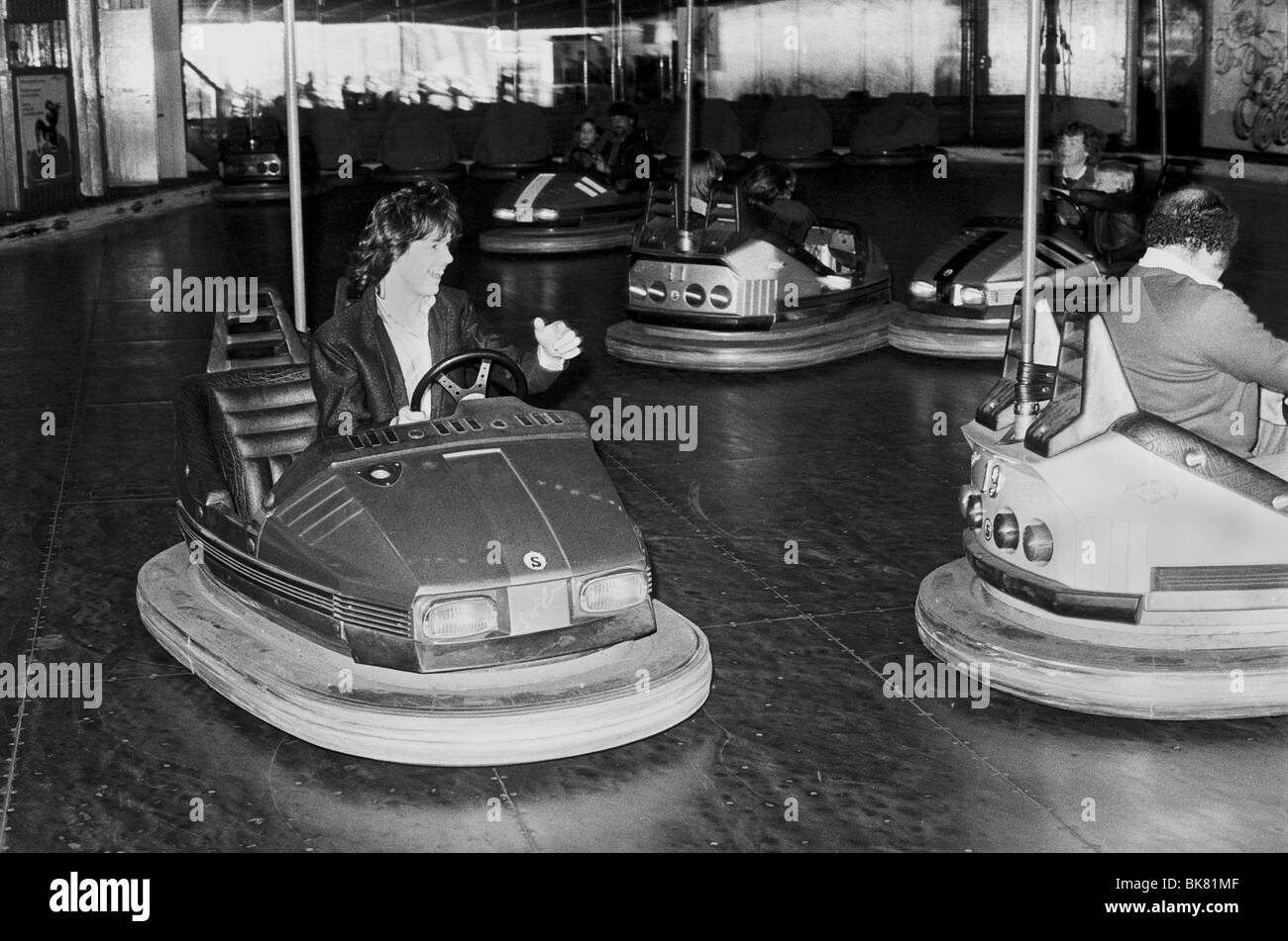 Gary Moore in un paraurti elettrico auto presso il parco dei divertimenti di Tivoli a Copenaghen durante la rock band Thin Lizzy tour della Scandinavia Foto Stock