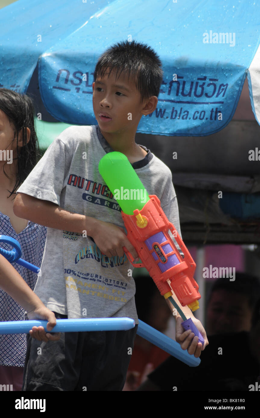 Giovane ragazzo armato di pistola di acqua durante il Thai Songkran Festival Foto Stock