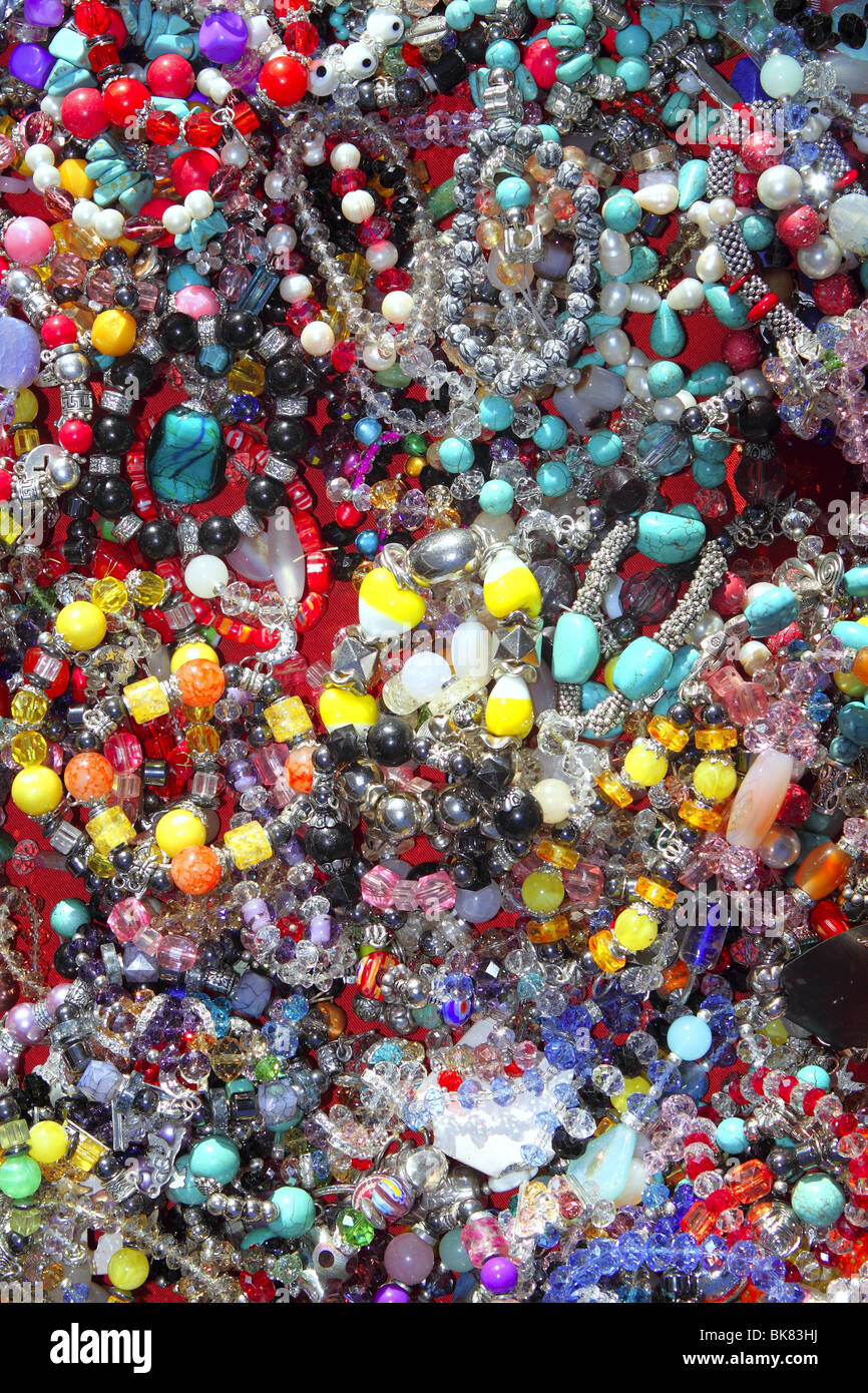 Gioielli colorati misti molti gioielli gioielleria di plastica sullo sfondo Foto Stock