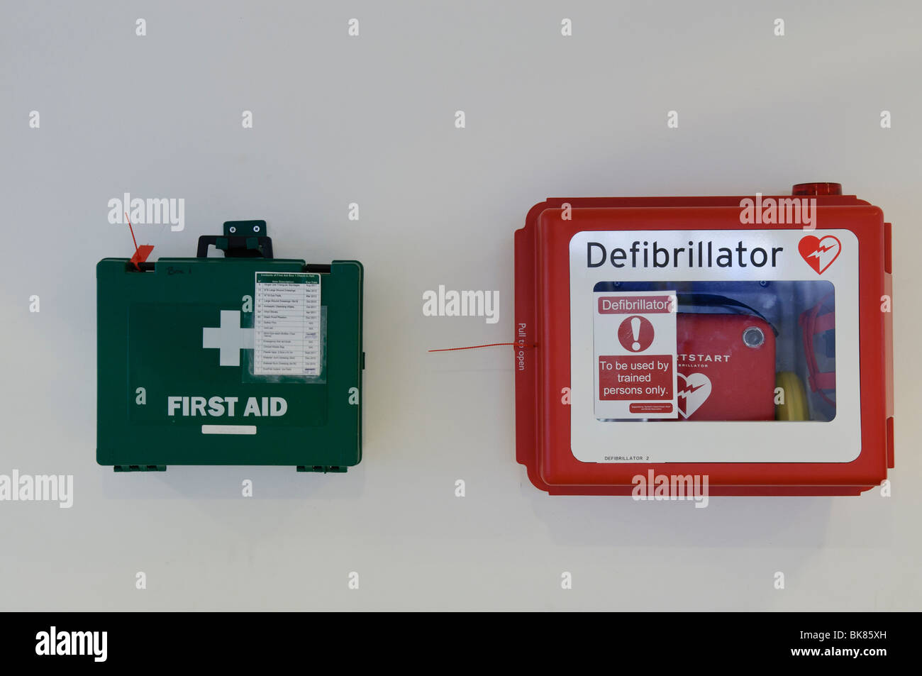 Kit di primo soccorso e di defibrillatore su una parete, pronto per l'uso Foto Stock