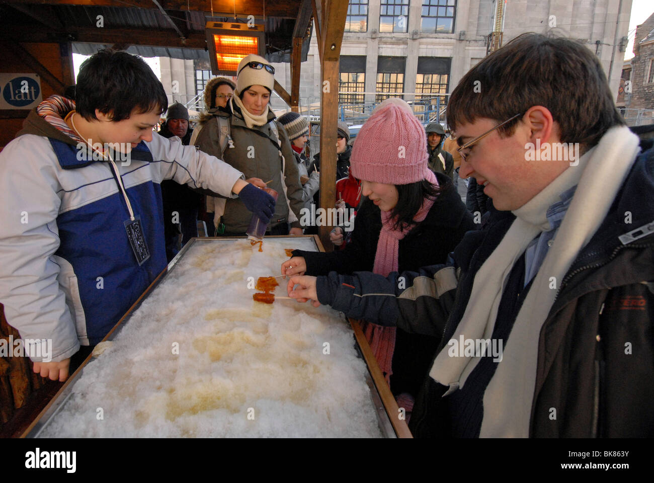 Persone mangiare lo sciroppo d'acero taffy realizzati su neve vecchia Montreal Canada Foto Stock