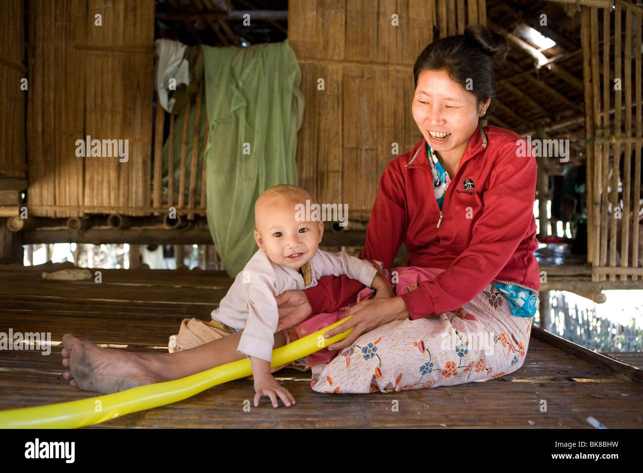 Una madre e un bambino nella loro casa di bambù nel campo per rifugiati di Mae La, per sfollati rifugiati birmani. Foto Stock