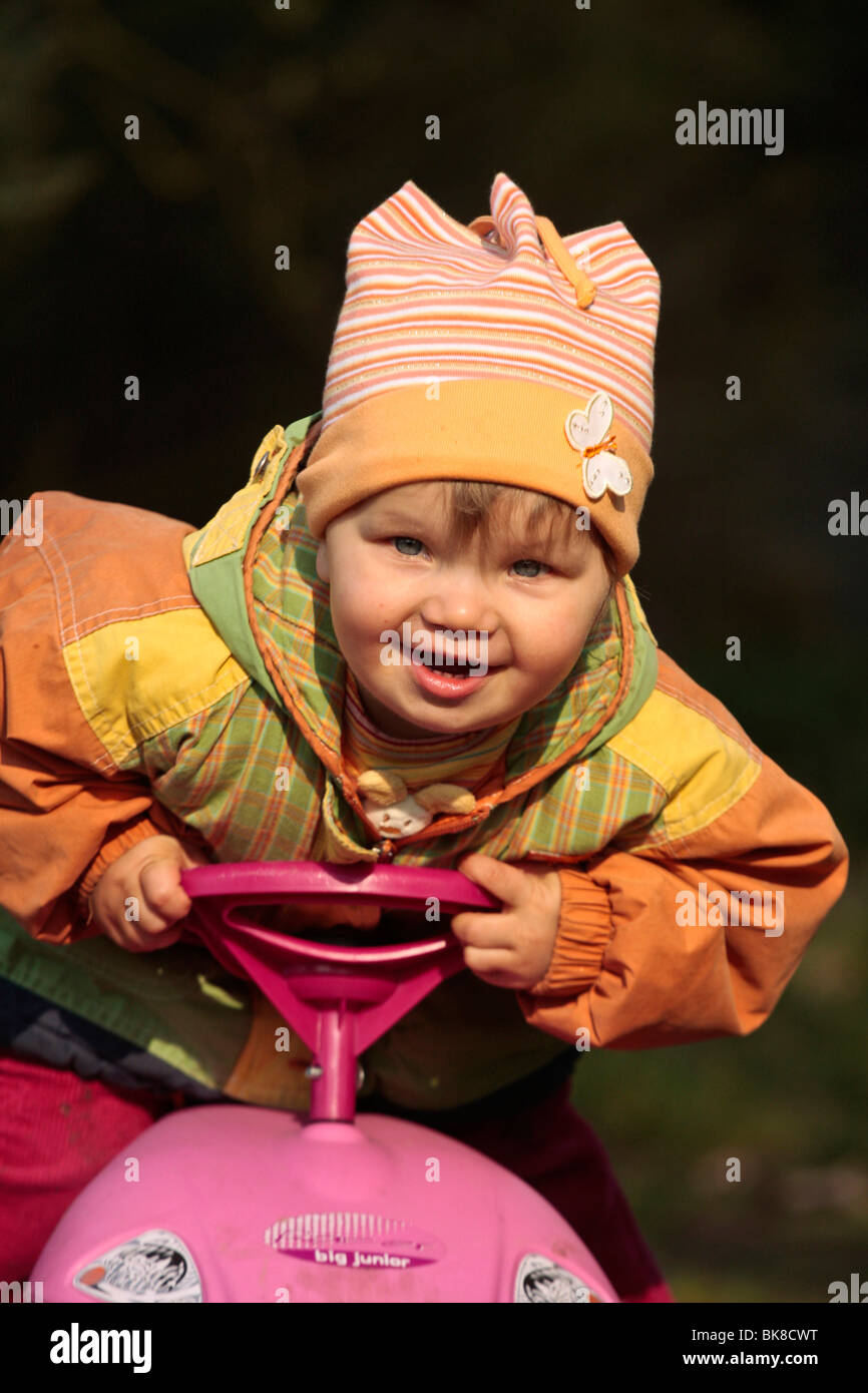 Bambina su un bobby-car, auto slitta Foto Stock