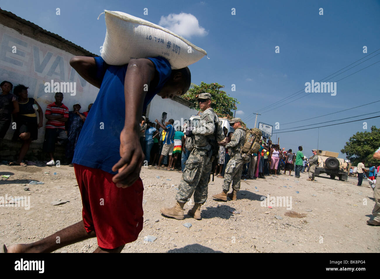 US Marine soldati di guardia durante la distribuzione del cibo nel centro cittadino di Port au Prince dopo un terremoto di magnitudine 7.0 ha colpito Haiti il 12 gennaio 2010 Foto Stock