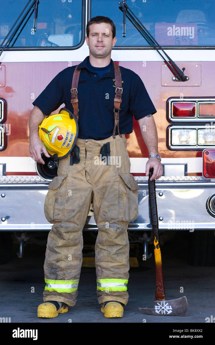 Fireman in piedi di fronte ad un camion dei pompieri Foto Stock