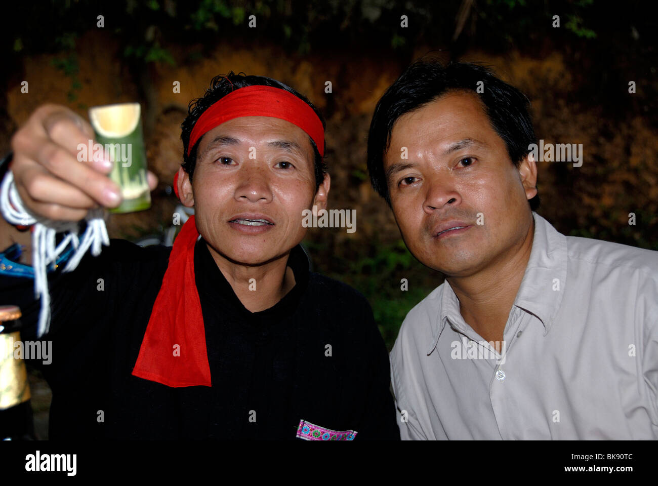 Cheers, uomini di etnia Phunoi bicchieri tintinnanti con Lao Lao, laotiana il vino di riso in vasi di bambù, Phongsali, Laos, Southe Foto Stock