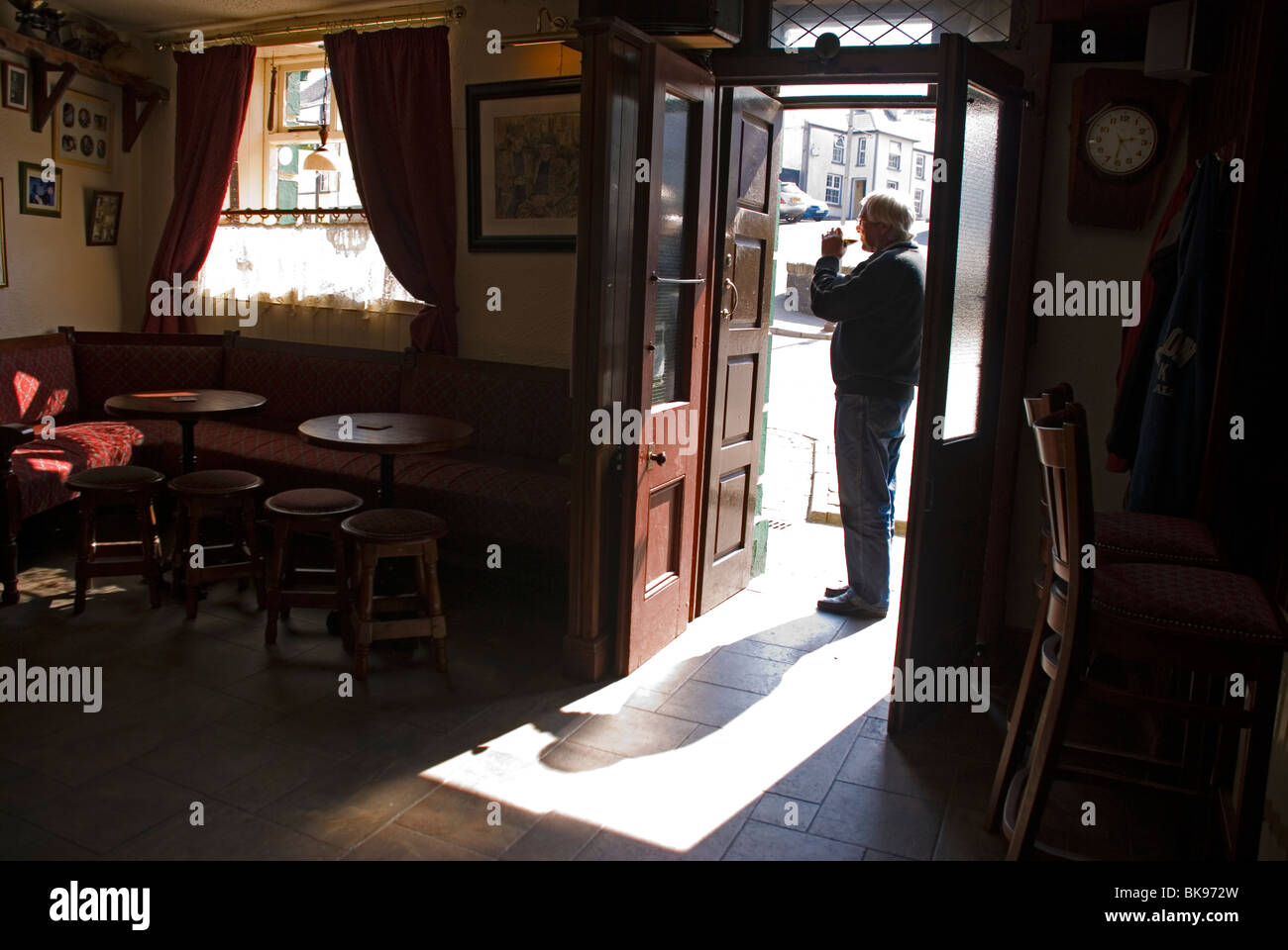 Uomo di bere una pinta di Guinness alla porta di un bar di Donegal Foto Stock
