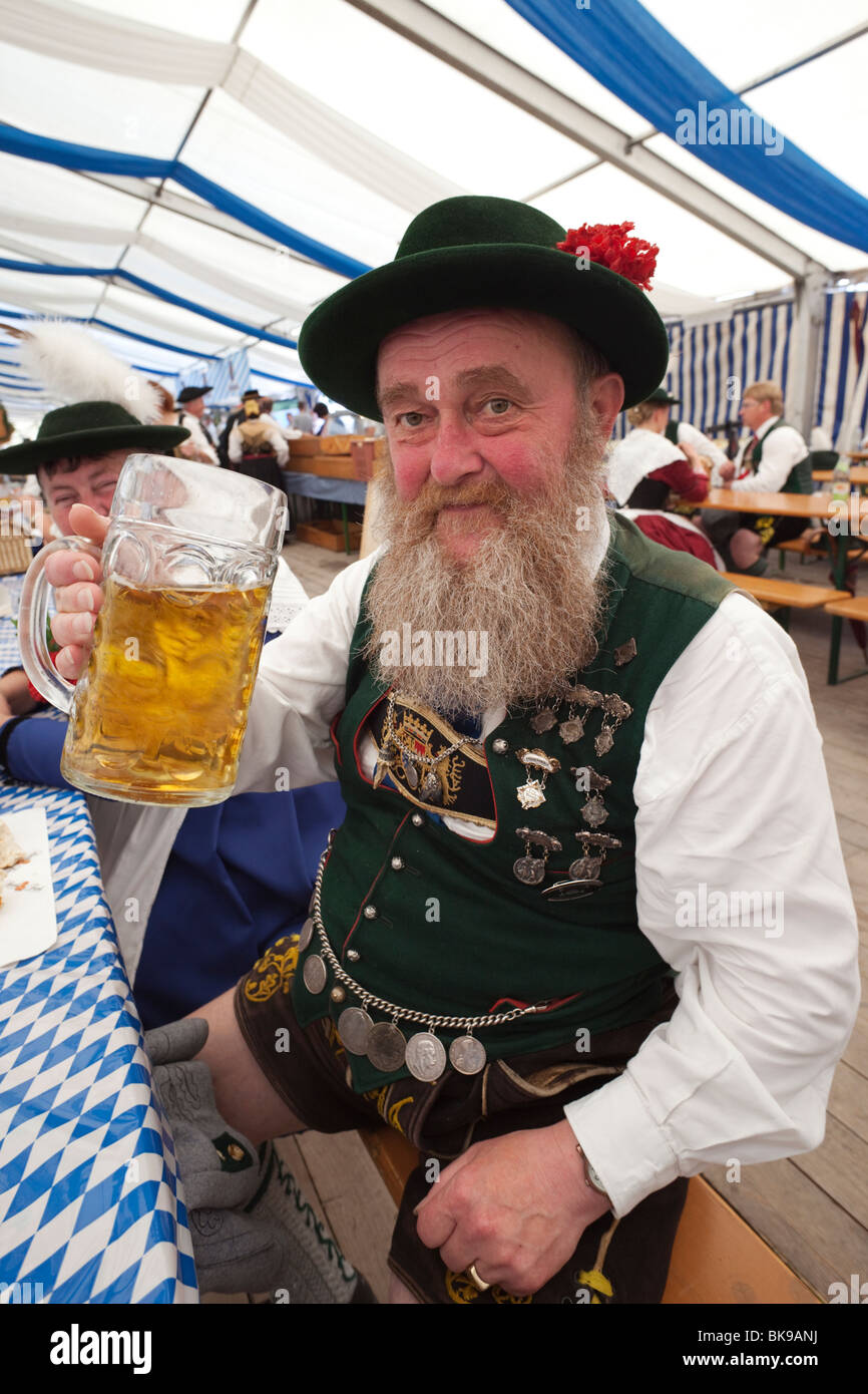 Senior uomo bere birra durante l'Oktoberfest Monaco di Baviera, Germania Foto Stock