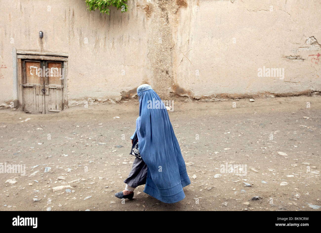 Un burqua placcati donna cammina il laneways di Kabul, Afghanistan. Foto Stock