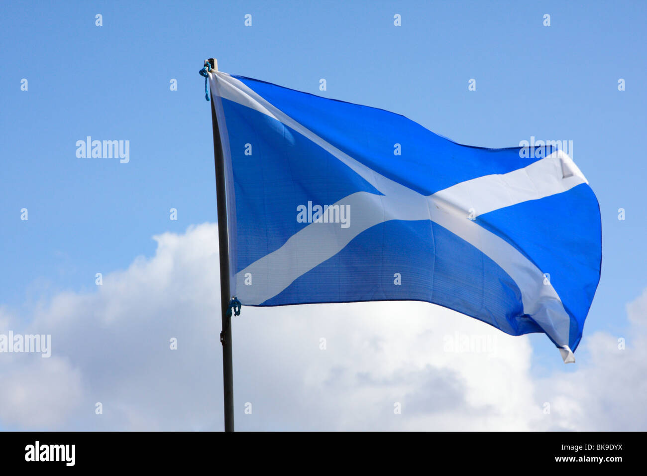Si intraversa, bandiera scozzese con il bianco di Sant'Andrea Croce su sfondo blu contro il cielo blu con nuvole bianche Foto Stock