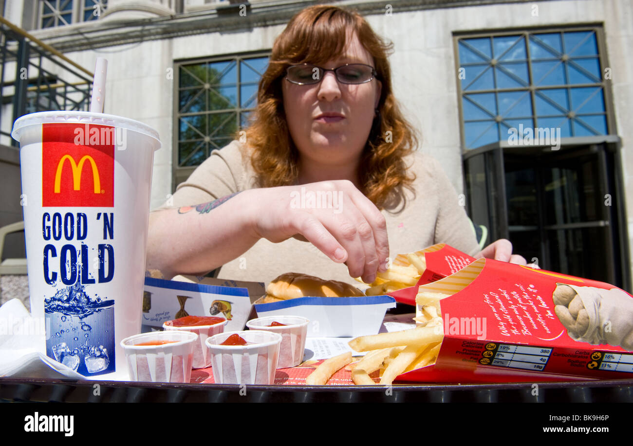 Donna sovrappeso mangiare McDonald's pasto veloce Foto Stock