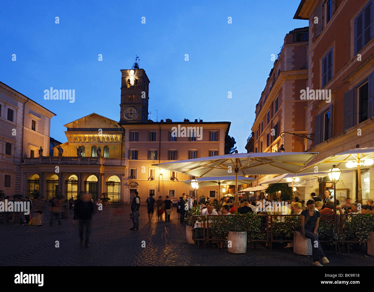 Gli ospiti in un cafe' sul marciapiede, chiesa di Santa Maria in Trastevere in background, Roma, Italia Foto Stock