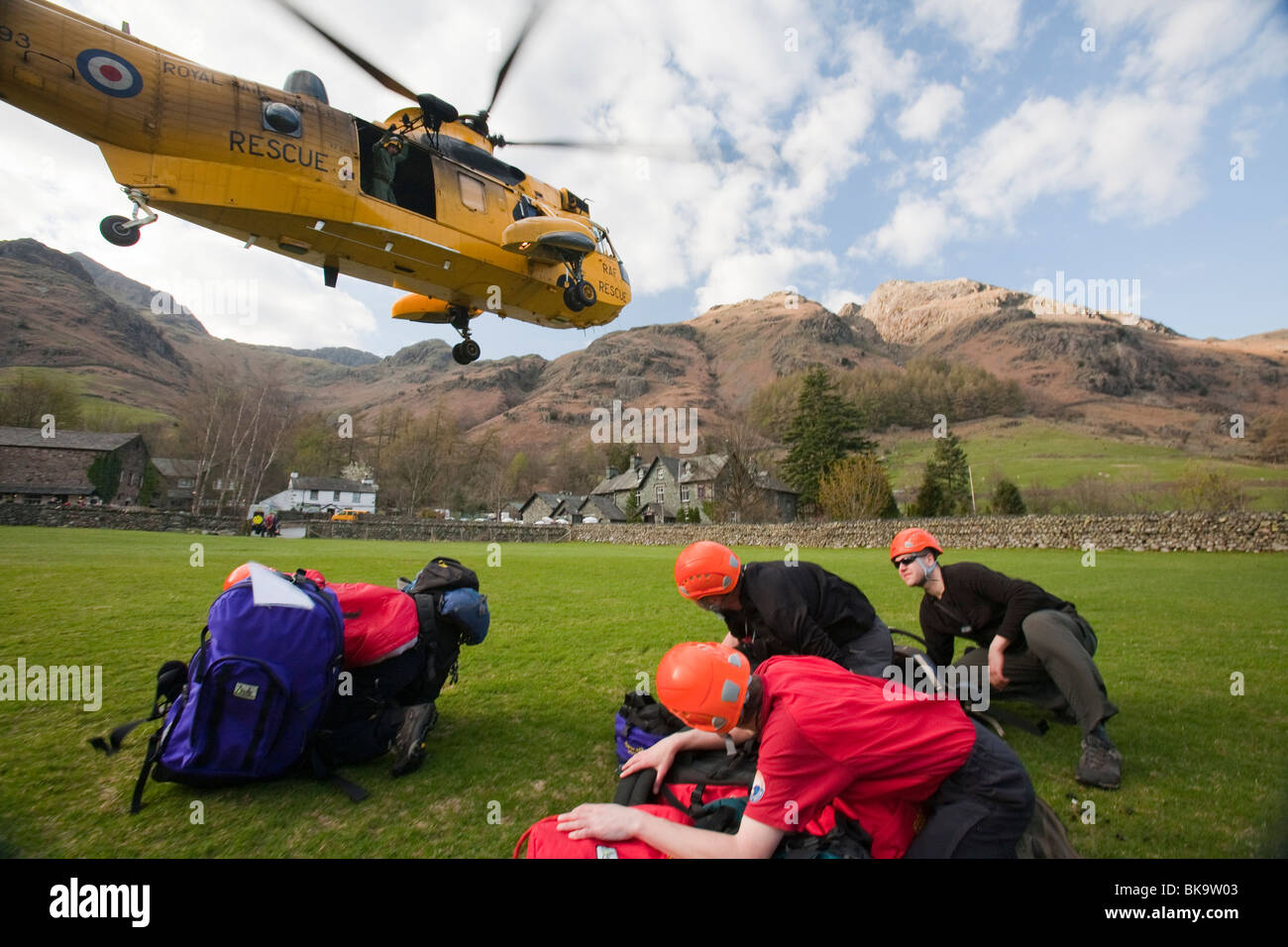 I membri di Langdale/Ambleside Mountain Rescue team uscire da un mare di RAF re elicottero durante un salvataggio in The Langdale valley Foto Stock