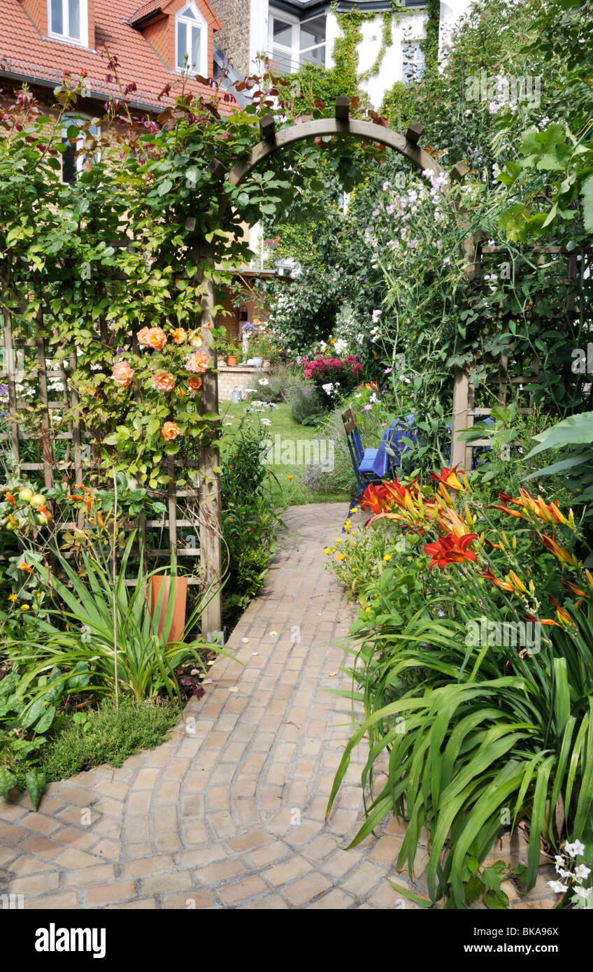 Le rose (rosa) e giorno gigli (Hemerocallis) in un giardino nel cortile. design: jutta wahren Foto Stock