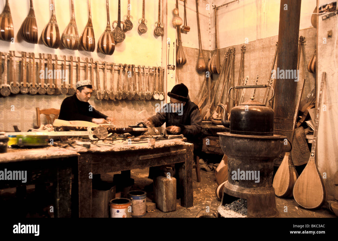 Selay Ababakri e figlio, Muhammad Turson sono uiguri fanno oltre 40 varietà di strumenti nel loro seminario di Kashgar city Foto Stock