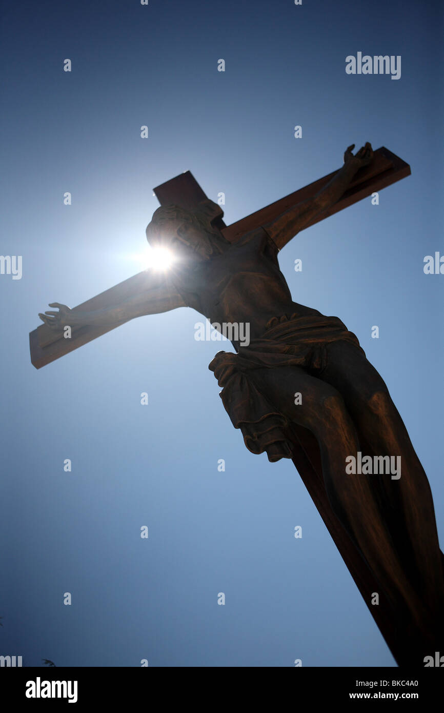 Una statua del Cristo crocifisso contro un perfetto cielo blu durante le celebrazioni pasquali a L'Aquila, Abruzzo, Italia Foto Stock
